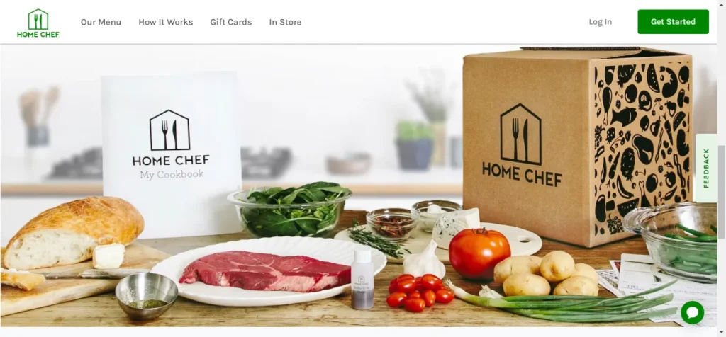 Home Chef meal kit display featuring a cookbook, raw steak, fresh vegetables, and a branded delivery box on a kitchen counter.