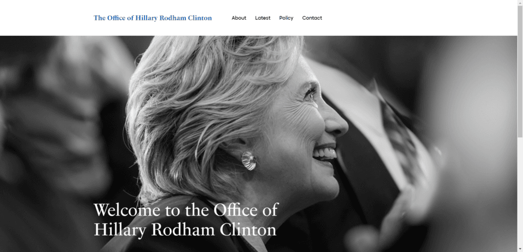 A screenshot of the official website for The Office of Hillary Rodham Clinton. The page features a large, black-and-white hero image of Hillary Clinton smiling in a crowd. White text overlaid at the bottom of the image reads, "Welcome to the Office of Hillary Rodham Clinton." The top navigation bar is simple and clean, containing the office name in blue text and menu links for About, Latest, Policy, and Contact.