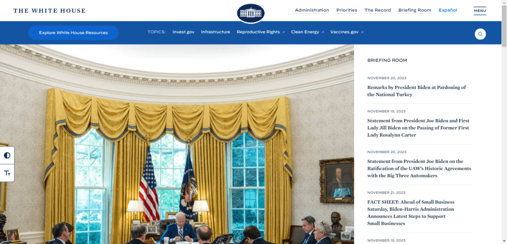 A screenshot of the official White House website featuring an image of President Biden and his staff in the Oval Office. The webpage includes a top navigation bar with links for Administration, Priorities, The Record, and Briefing Room. A sidebar titled "BRIEFING ROOM" lists several recent press releases and statements from November 2023, including remarks on the pardoning of the National Turkey and statements regarding the passing of former First Lady Rosalynn Carter. Links to topics such as Infrastructure, Reproductive Rights, and Clean Energy are also visible.